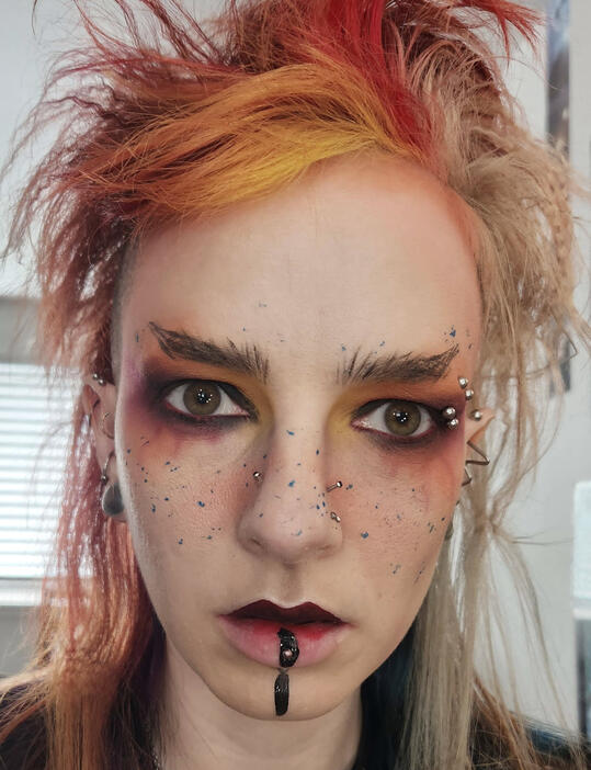 R.M. Thorne Profile picture of the editor wearing elaborate, gothic makeup. They have multicolored red hair.